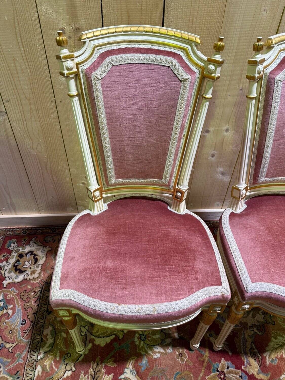 Louis XVI dining room table set with painted wood, gold accents, and pink velvet.