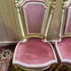 Louis XVI dining room table set with painted wood, gold accents, and pink velvet.