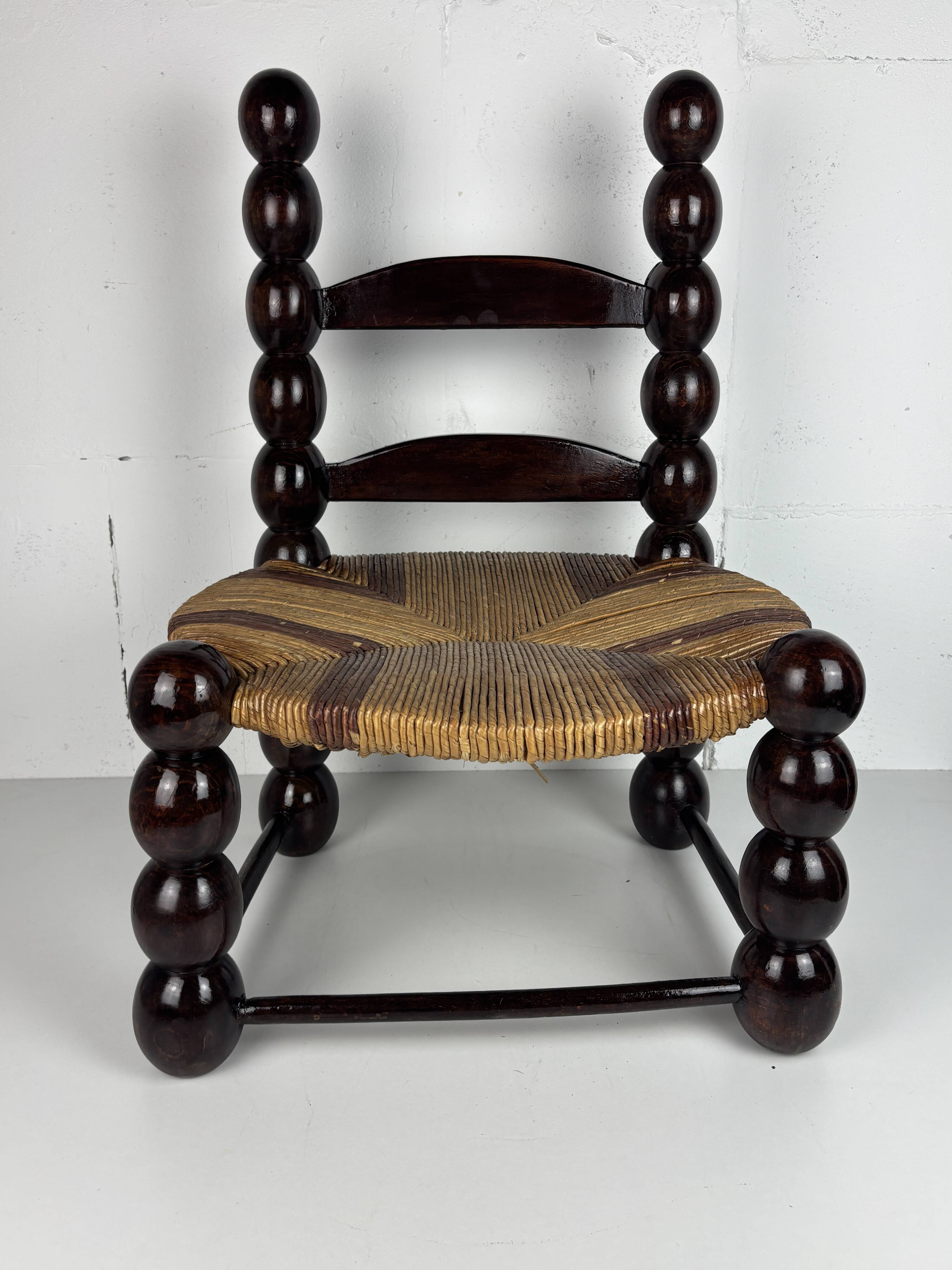 Brutalist wood turned bobbin low rush chair n the style of Charles Dudouyt