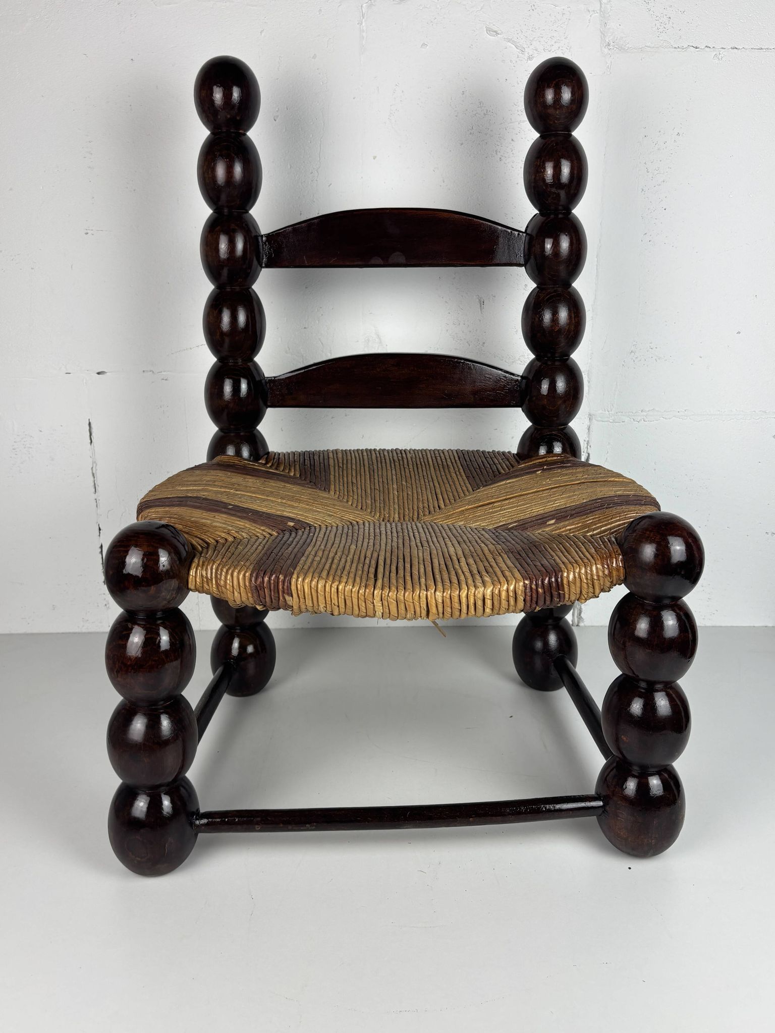 Brutalist wood turned bobbin low rush chair n the style of Charles Dudouyt