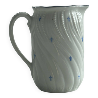 White porcelain milk jug with blue fleur-de-lis patterns.