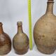 Set of three old enamelled terracotta bottles, 33 cm