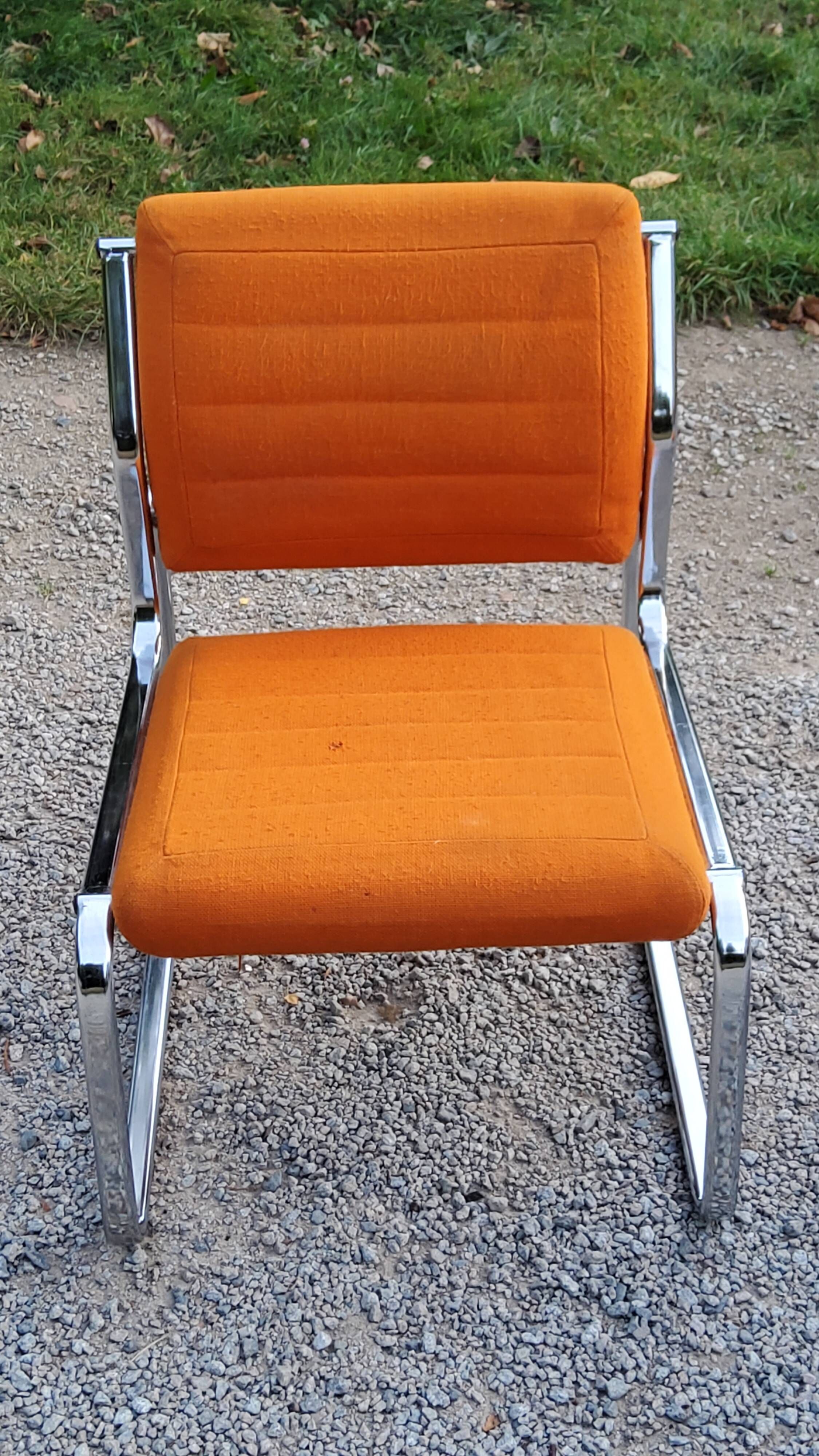 Pair of designer armchairs in orange fabrics and chrome tubes from the 70s