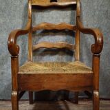 Empire armchair in solid walnut with woven straw seat.