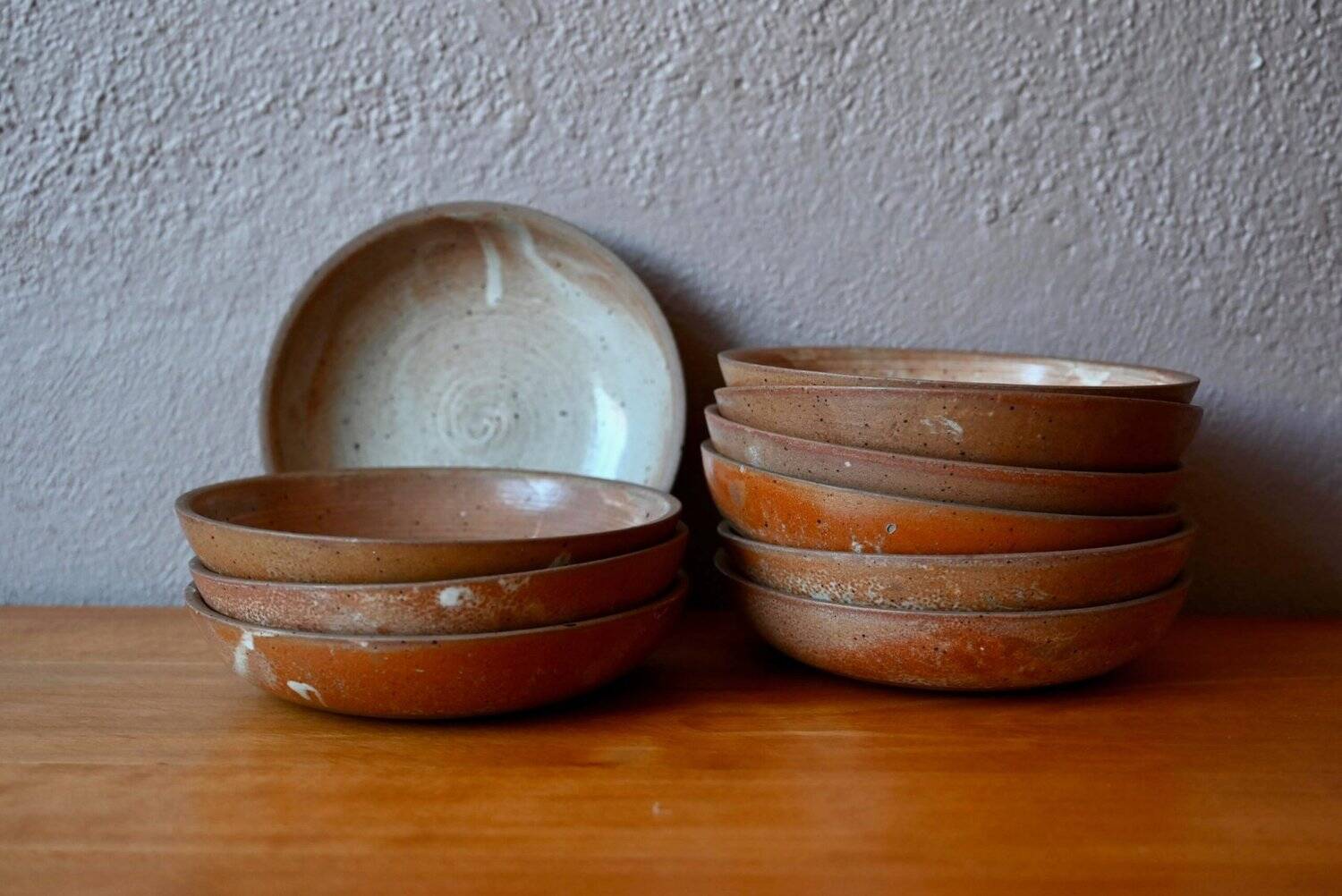 Set of 10 turned stoneware plates, pyritised and glazed, wabi-sabi brutalist.