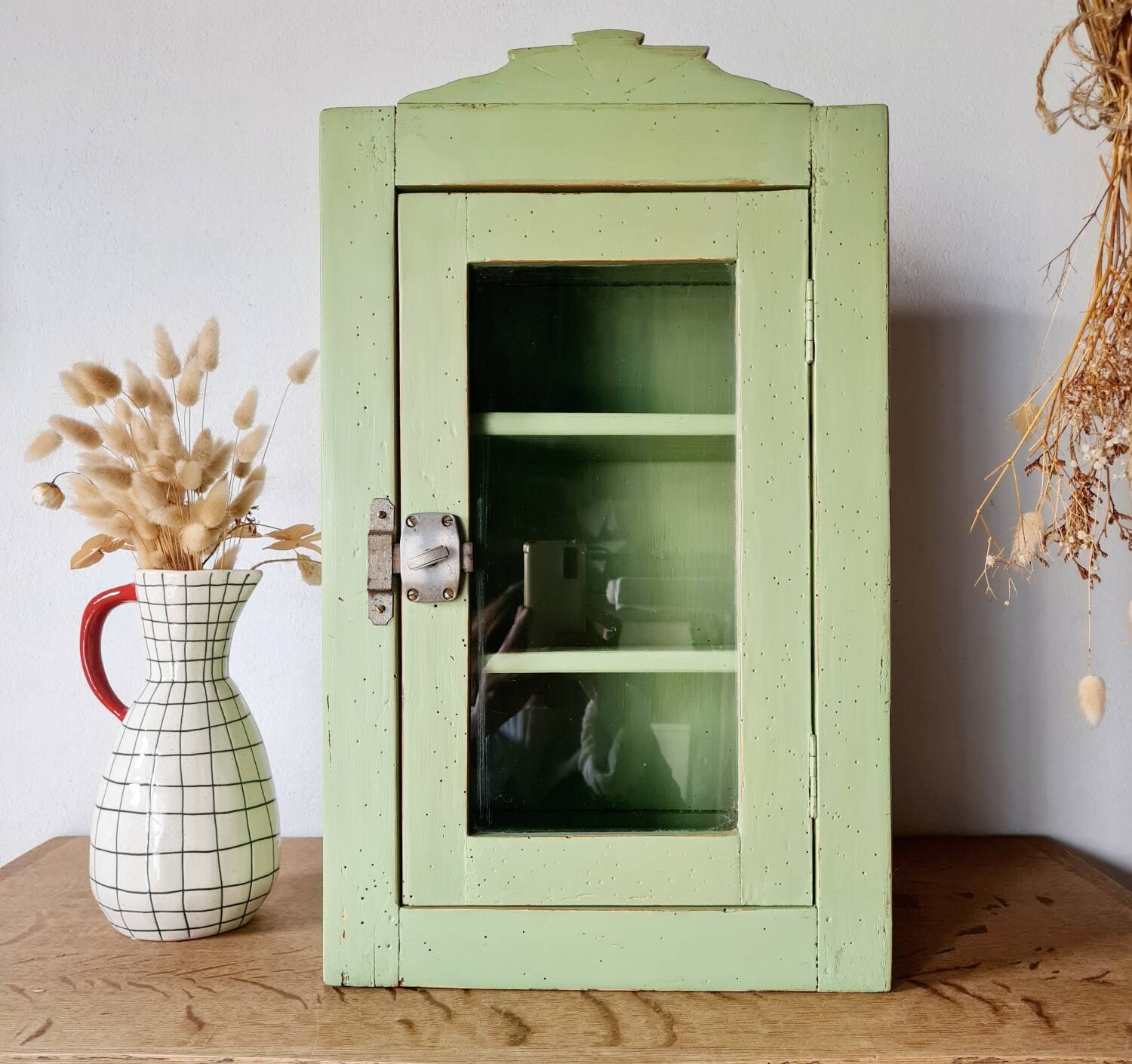 Small glass cabinet in green colour.