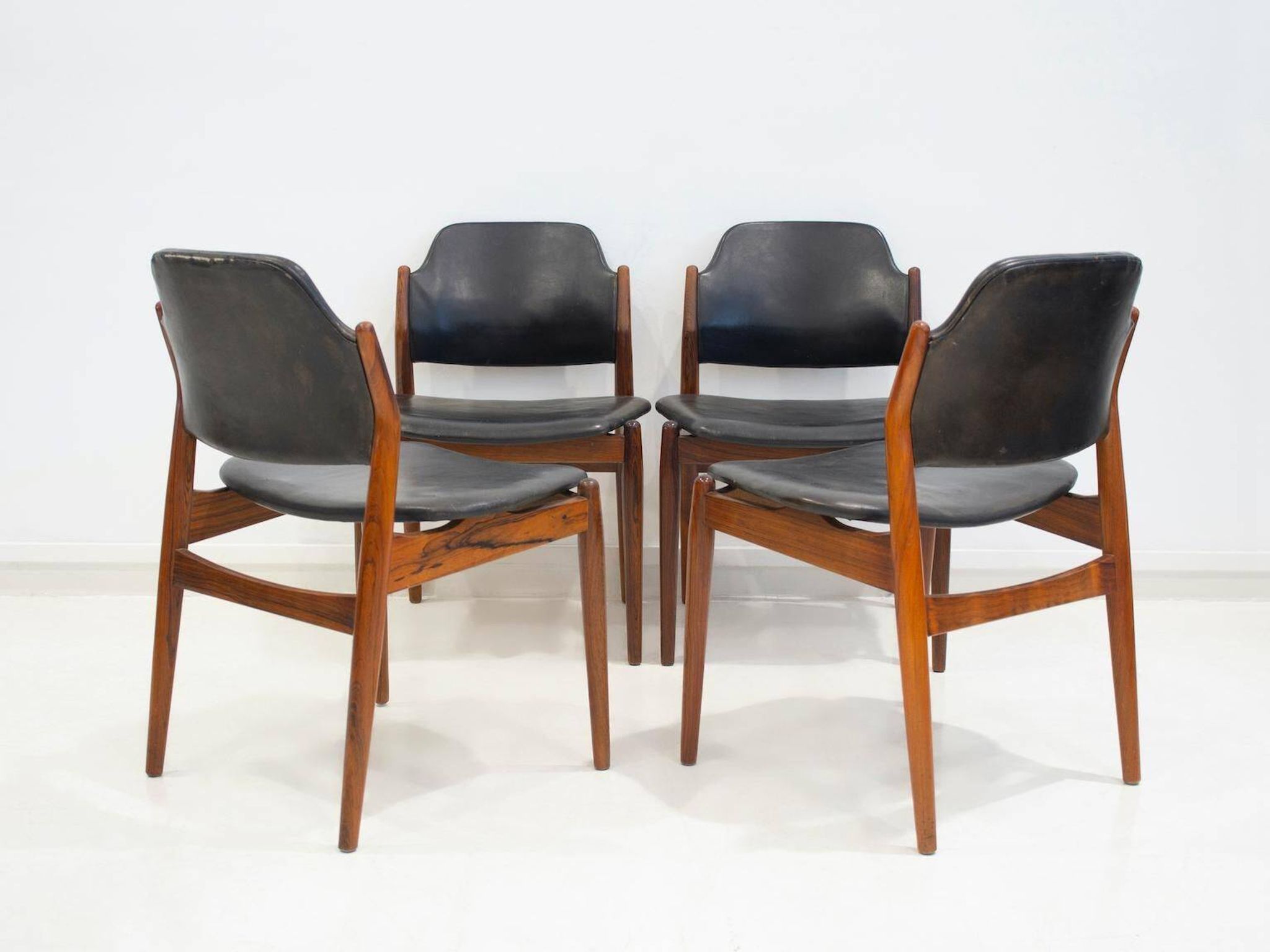 Set of four Arne Vodder chairs in hardwood and black leather.