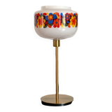 Table lamp with a vintage “flower power” glass globe and a gold base