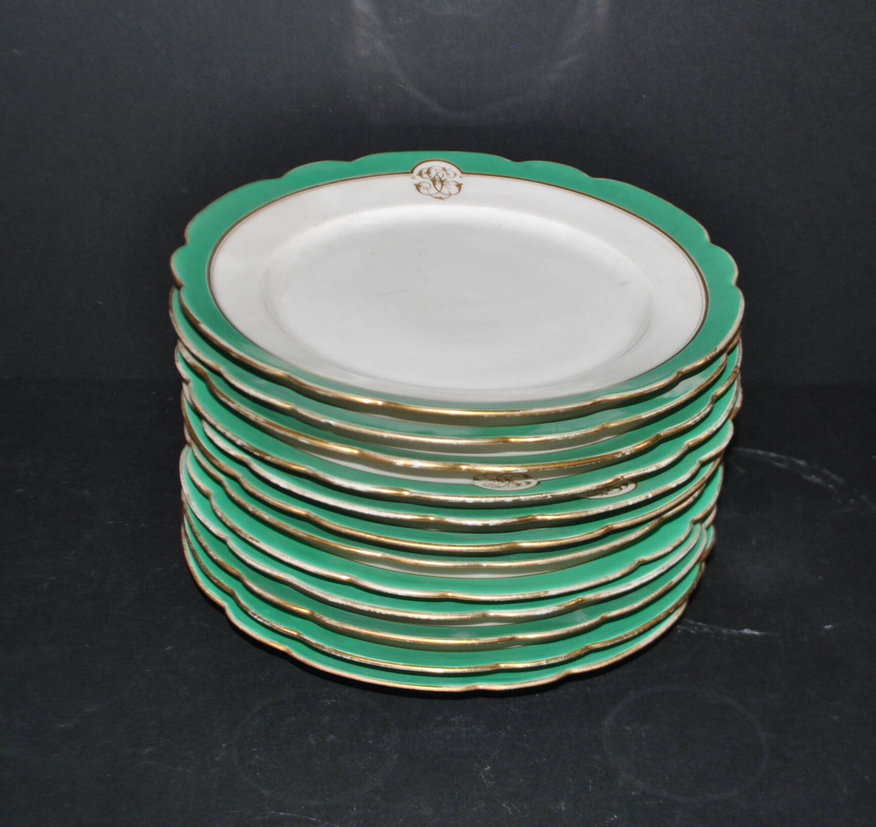 Paris porcelain set of 12 flat plates with green border and gold monogram JC.