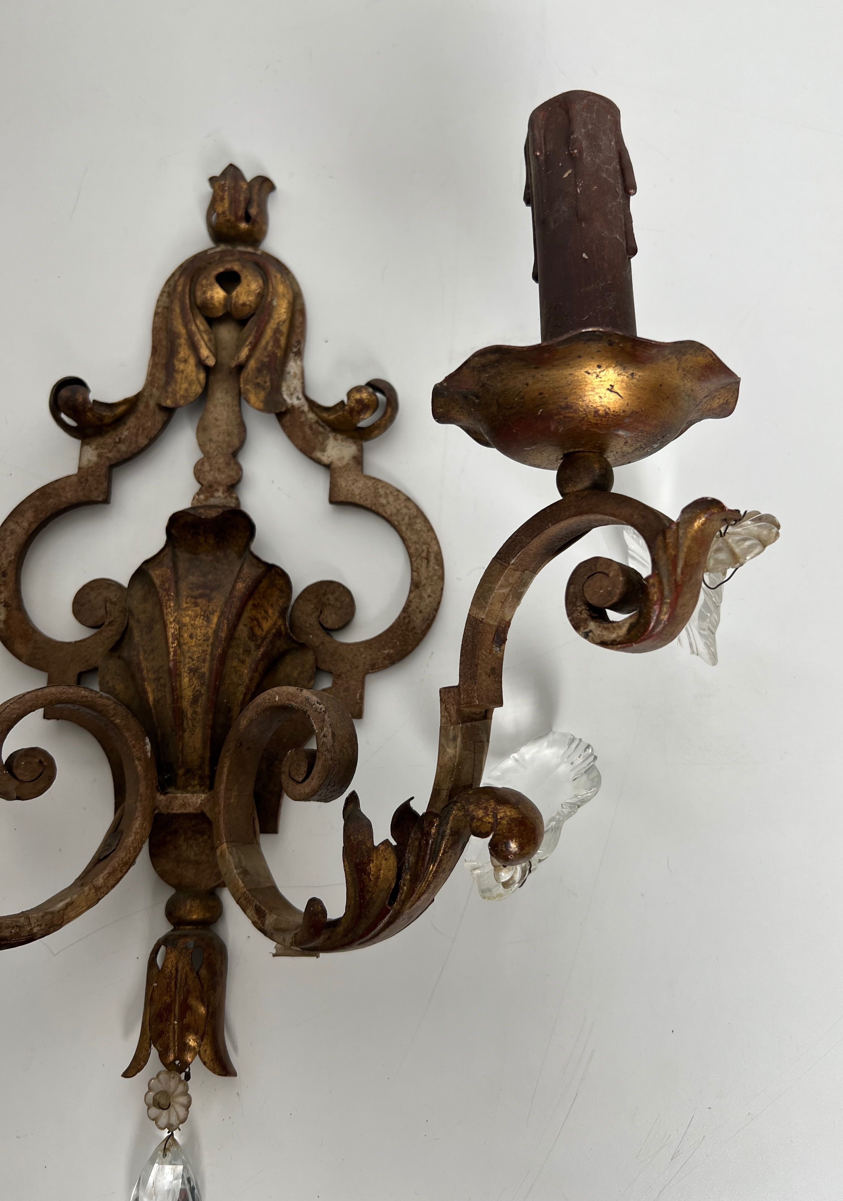 Pair of patinated wrought iron wall sconces with golden acanthus leaves and crystals.