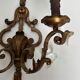 Pair of patinated wrought iron wall sconces with golden acanthus leaves and crystals.