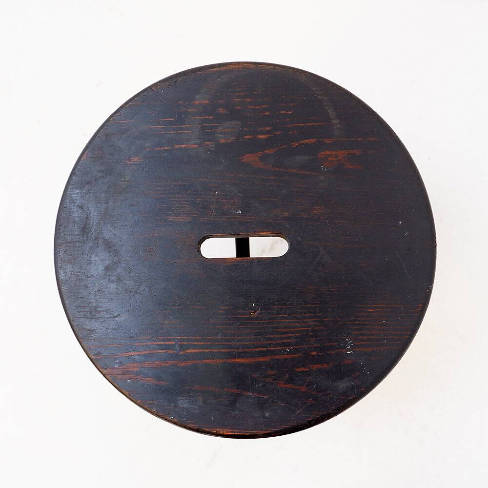 Vintage black-stained wooden tripod stool with mortise joints.