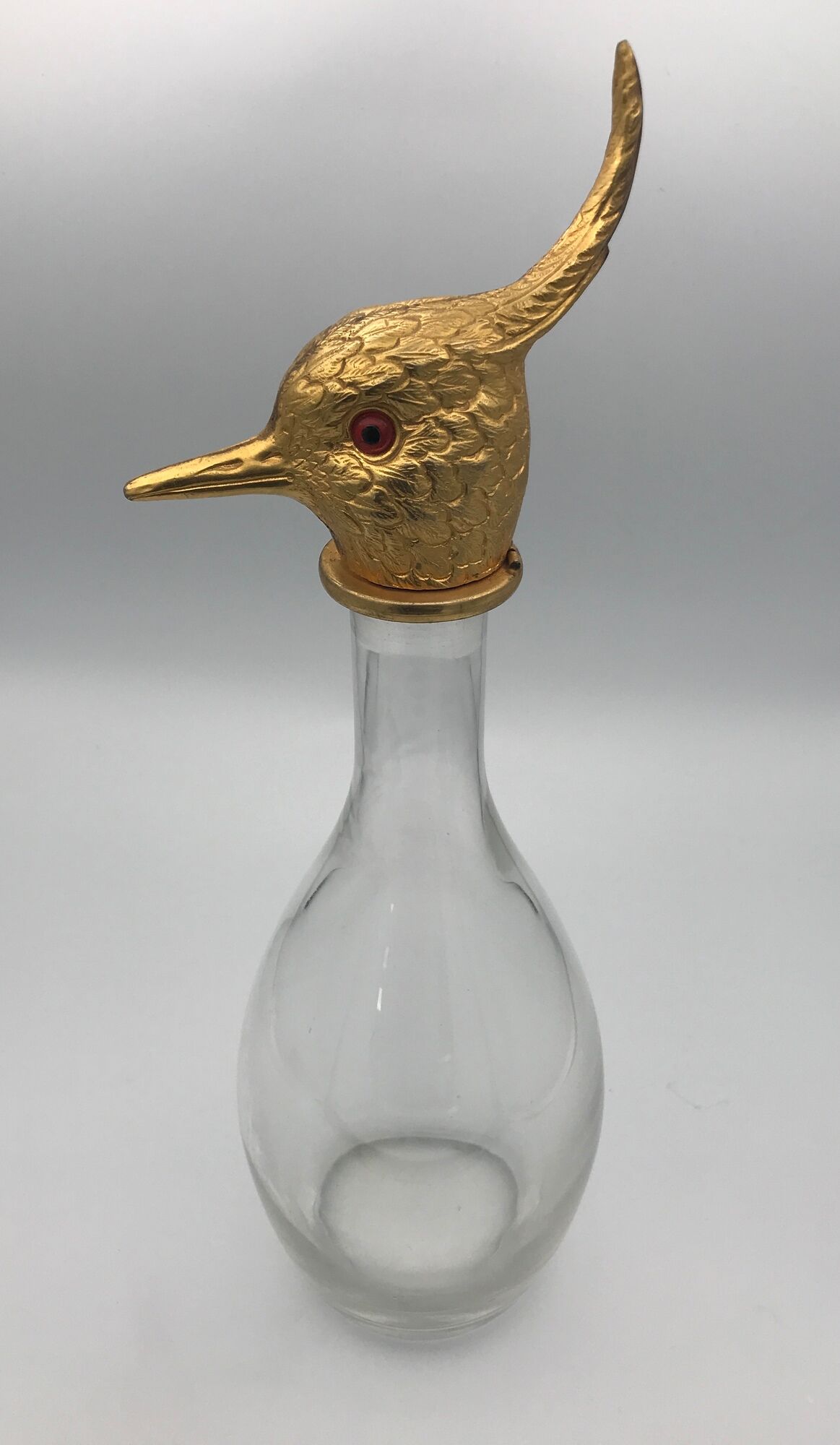 Glass bottle type carafe with gold metal bird head stopper