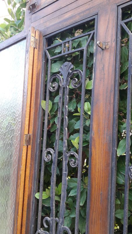 Oak entrance door and its frame and transom, wrought iron gates