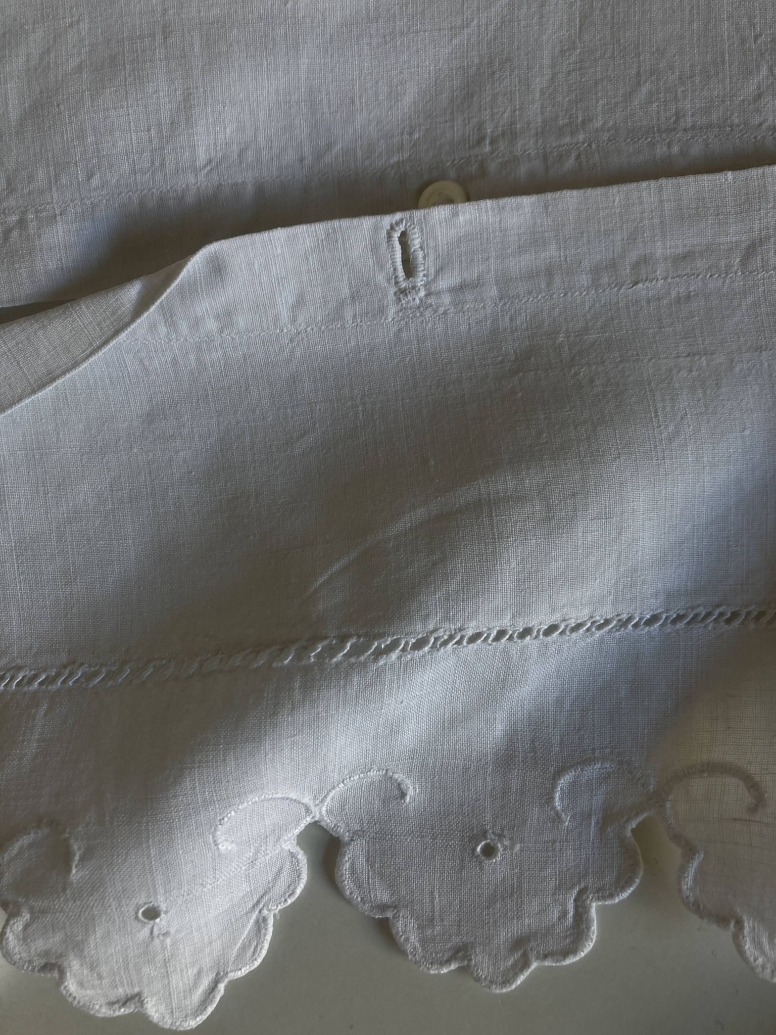 Pair of 19th-century linen pillowcases embroidered with scallops.