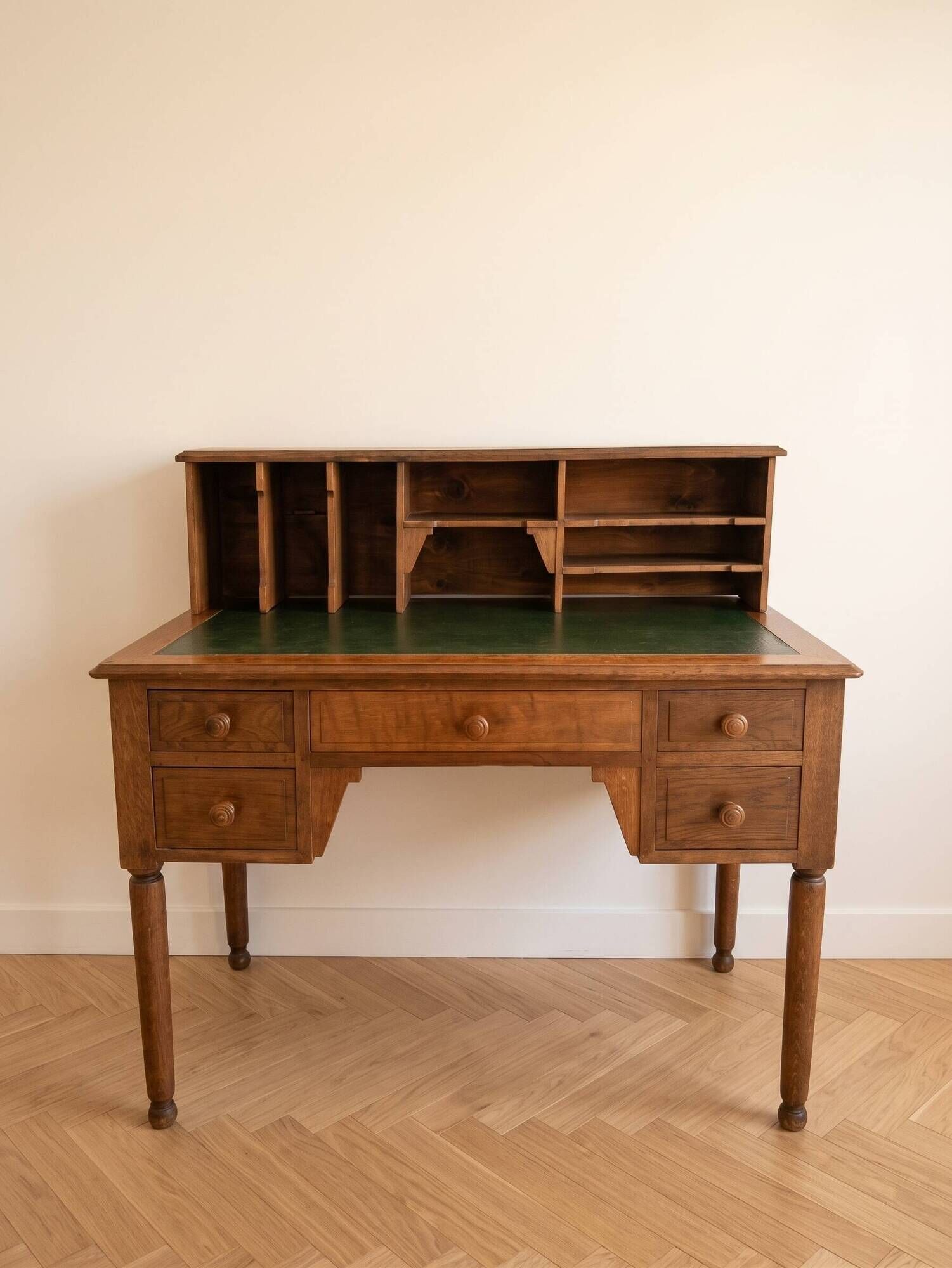 Antique wooden desk with a sloped top and green writing pad.