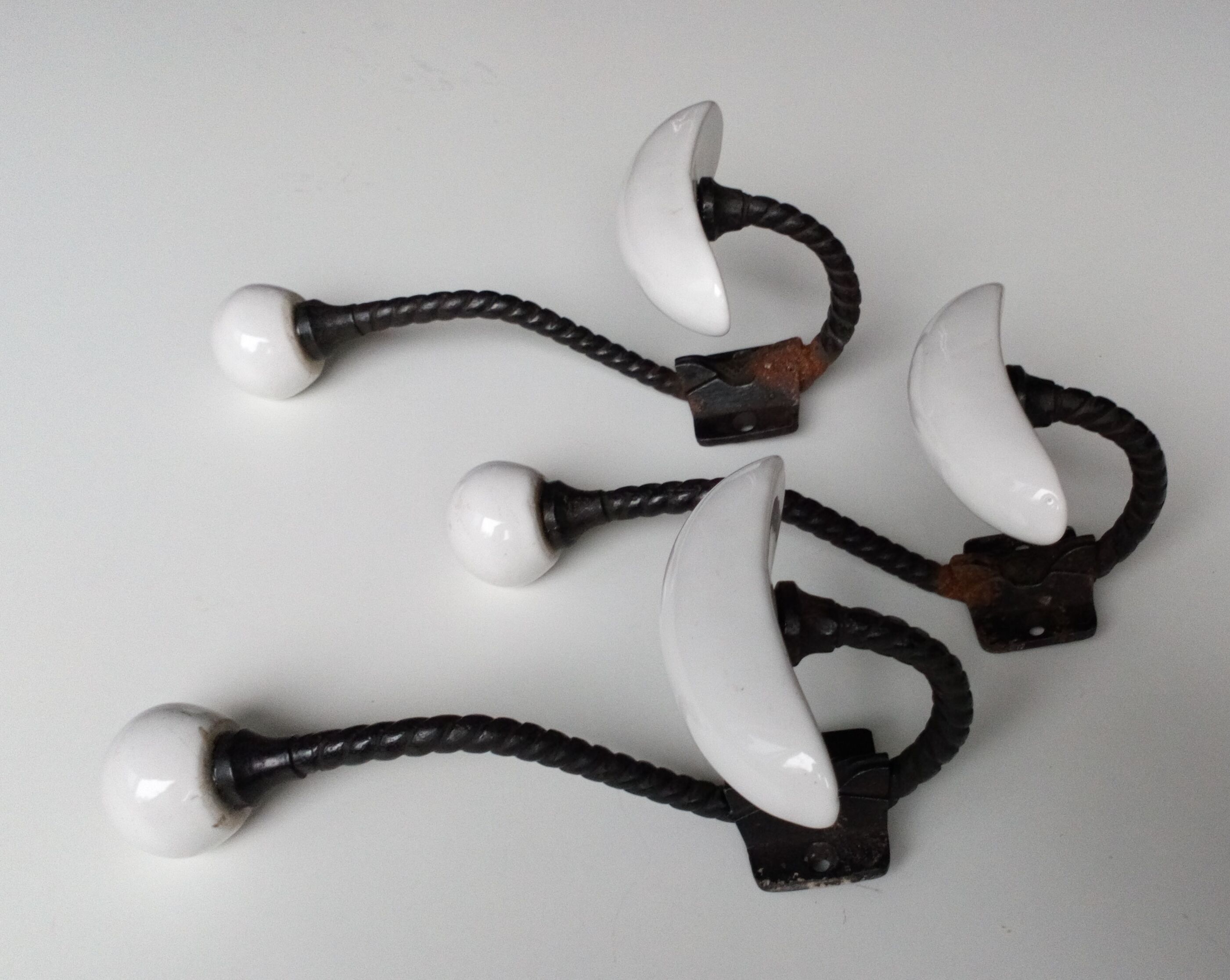 Trois patères doubles en fer forgé et porcelaine