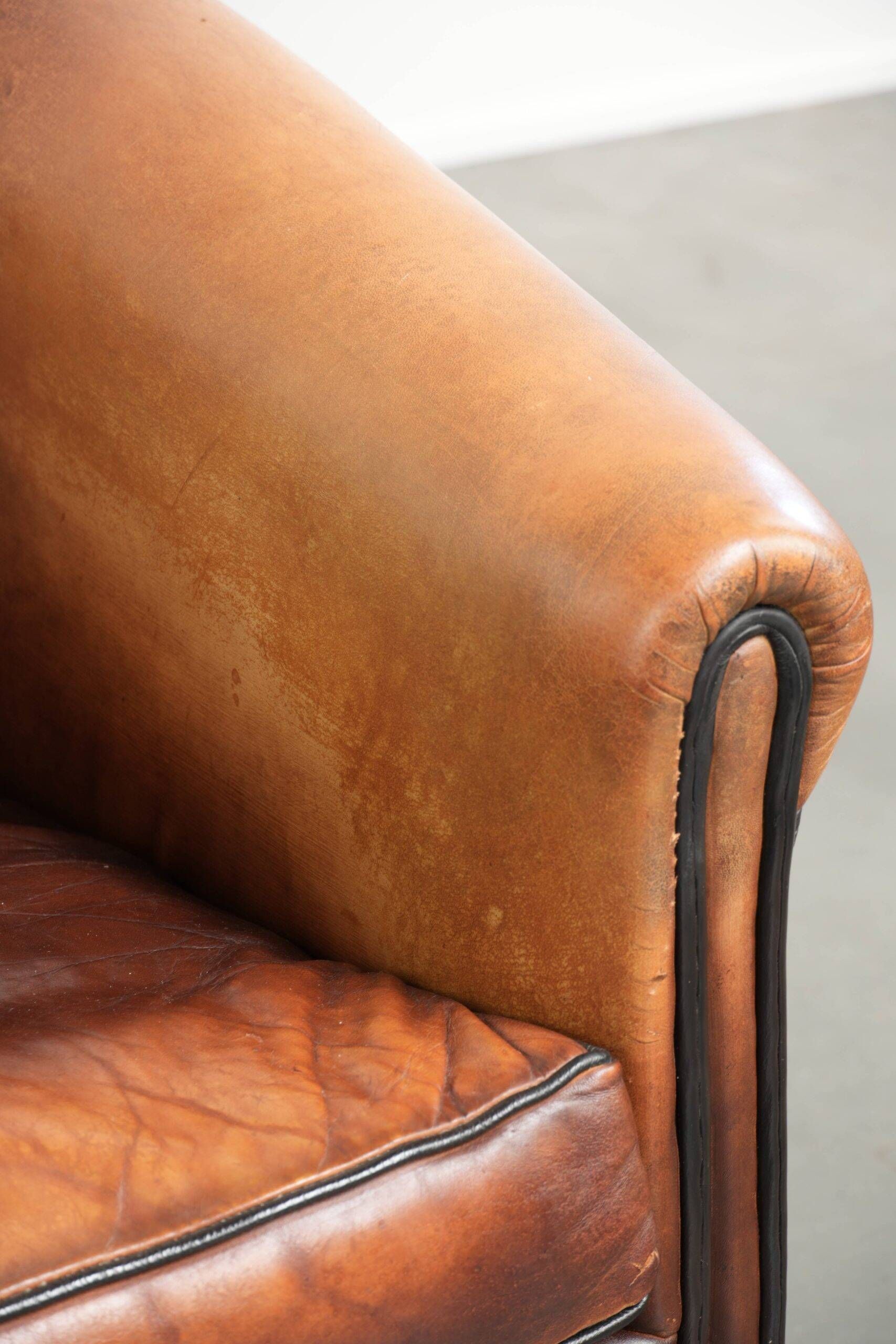 Vintage sheepskin club armchair finished with black piping