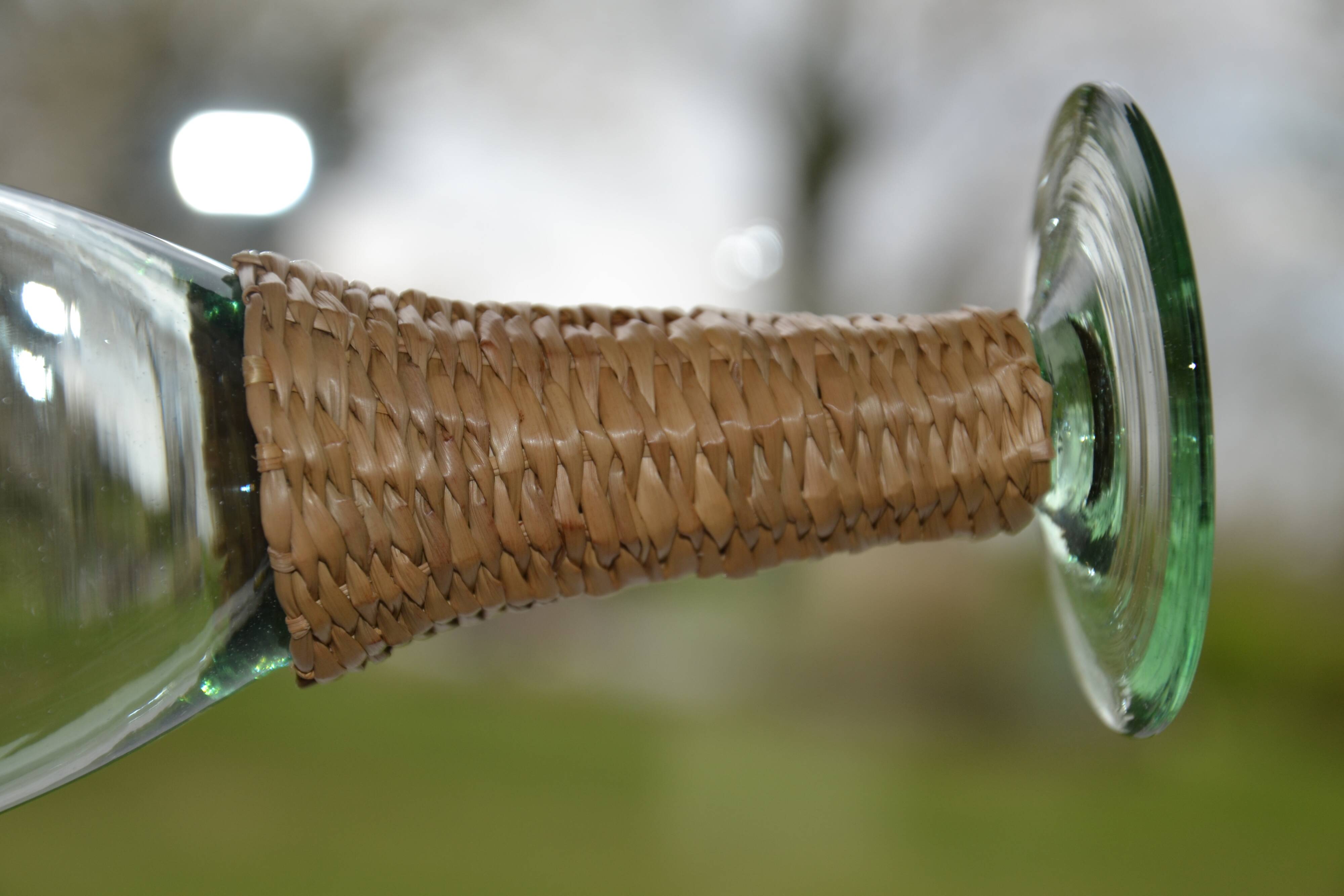 Four stemmed glasses surrounded by rattan.
