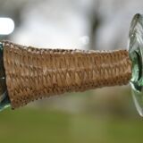 Four stemmed glasses surrounded by rattan.
