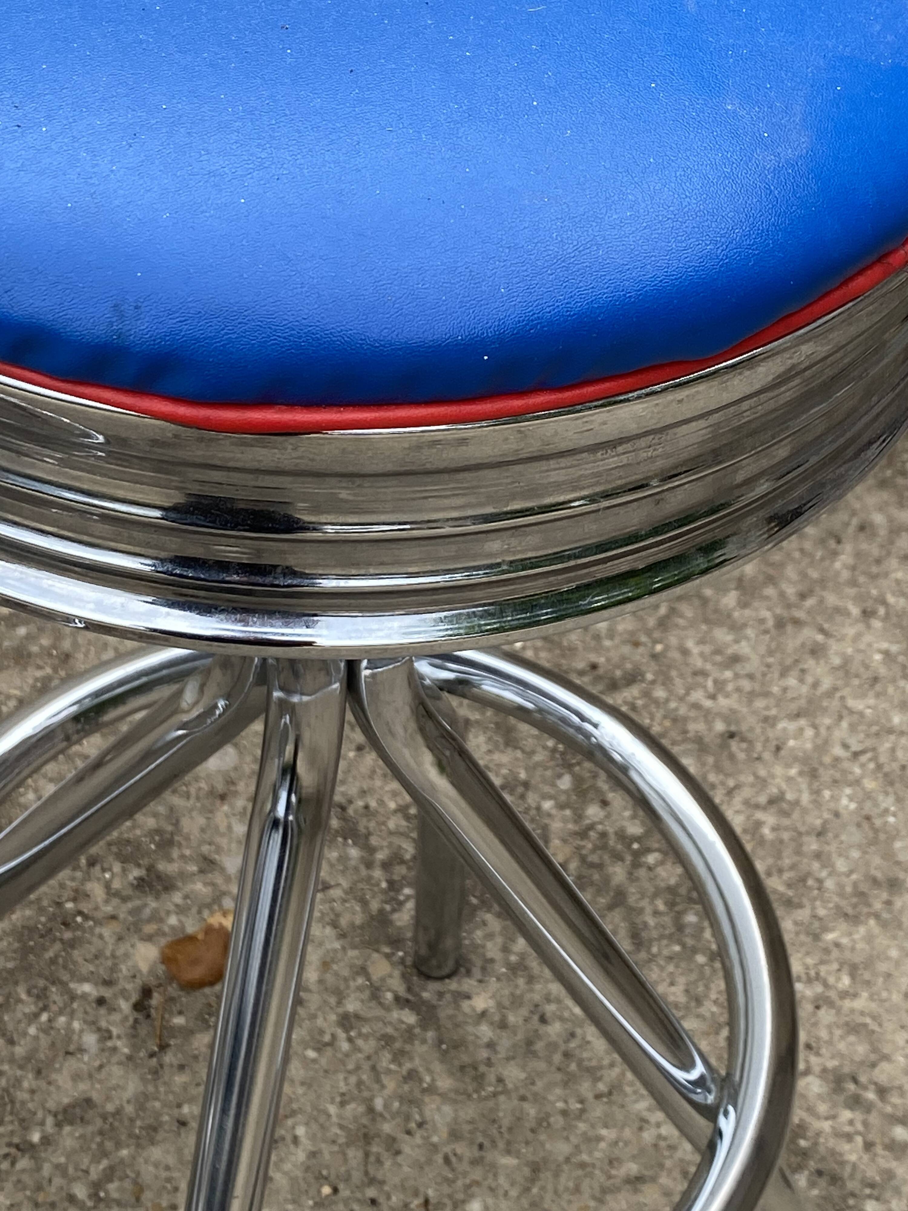 Set of 5 vintage swivel bar stools in blue, red, orange, and yellow.