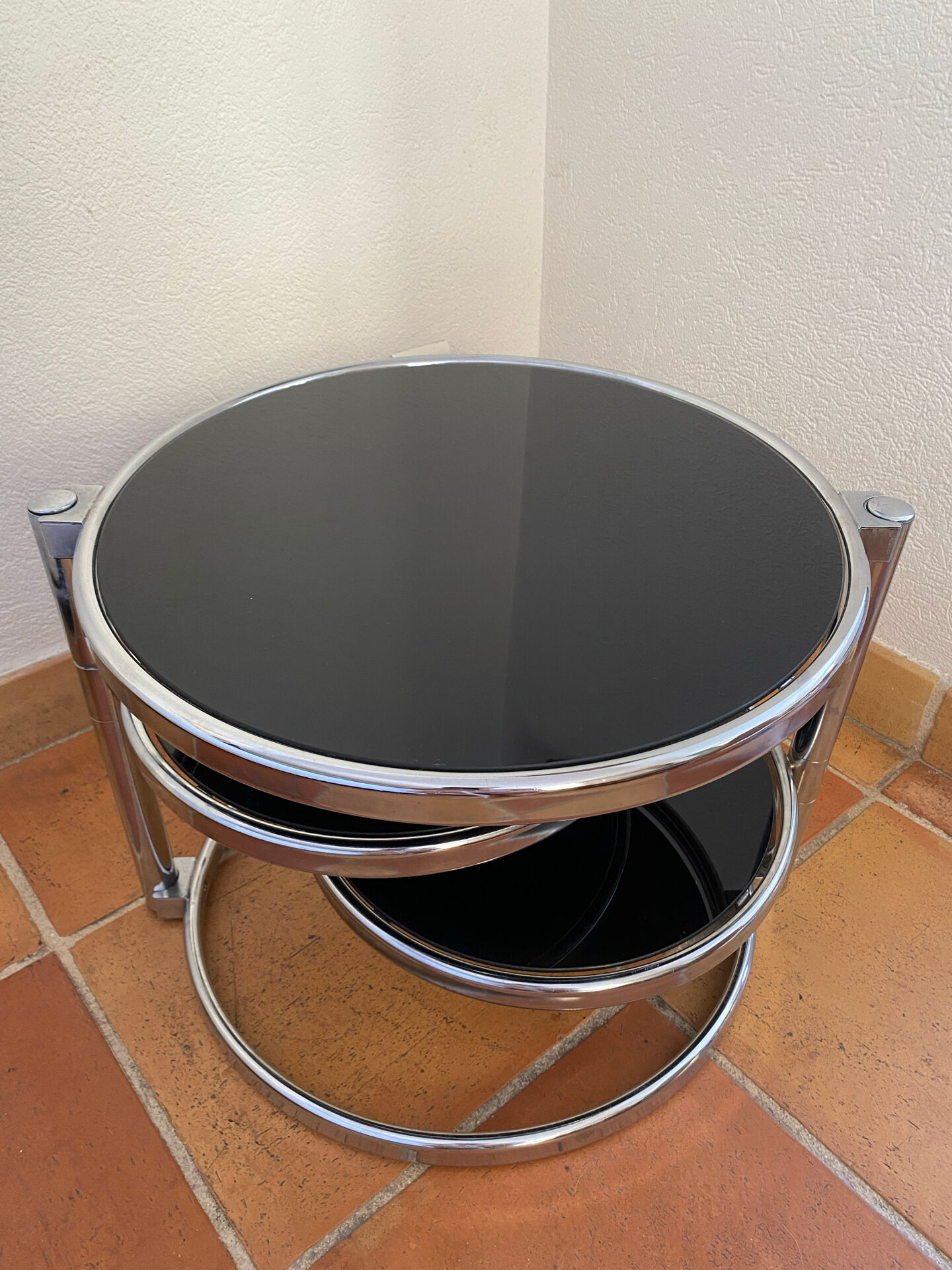 Coffee table with pivoting metal and black glass elements.