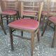 Set of 19 vintage wooden bistro chairs with red faux leather.