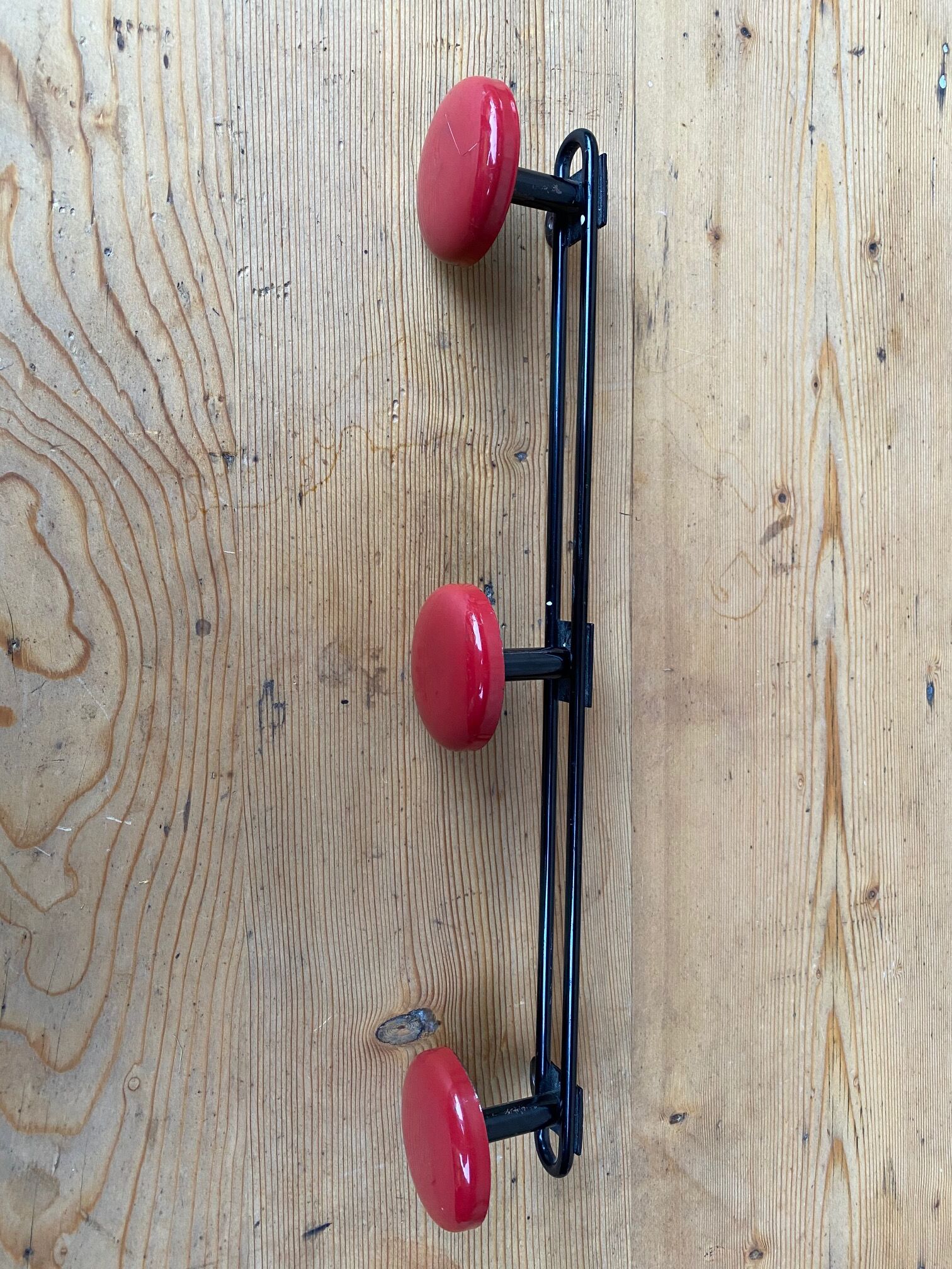 Wall coat holder in vintage red metal.