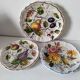 Set of three earthenware plates from Bassano, hand-painted with fruit and flower designs.