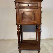Antique wooden bedside table with turned legs.