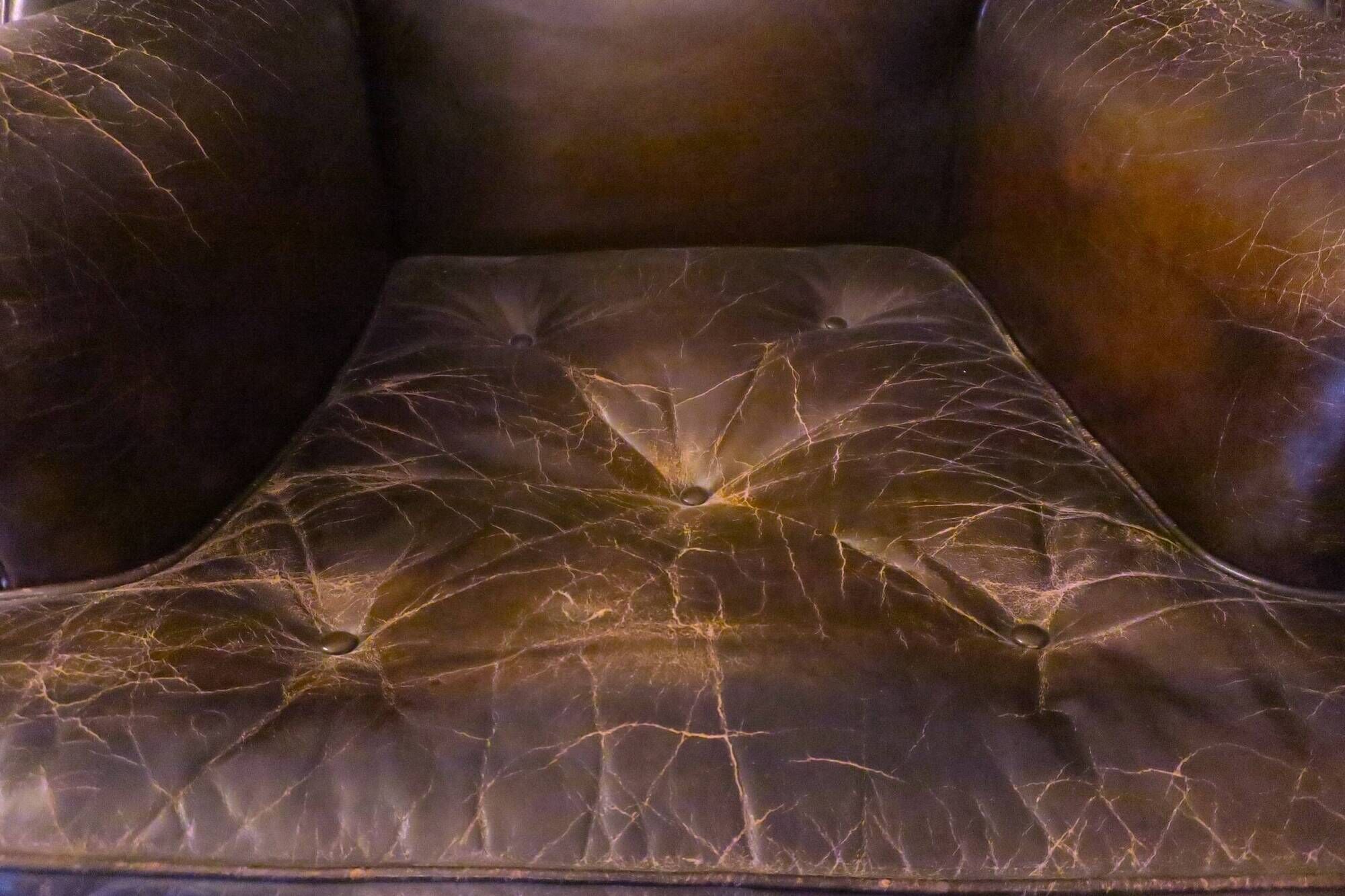Wingback armchair in dark brown patinated leather, 1970s