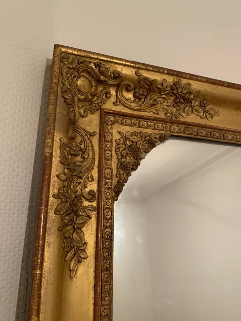 Nineteenth century mirror in wood and stucco gilded with rich gold leaf ornamentation, 101x127 cm