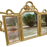 Triptych-shaped mirror in gilded wood and carved with a frieze
