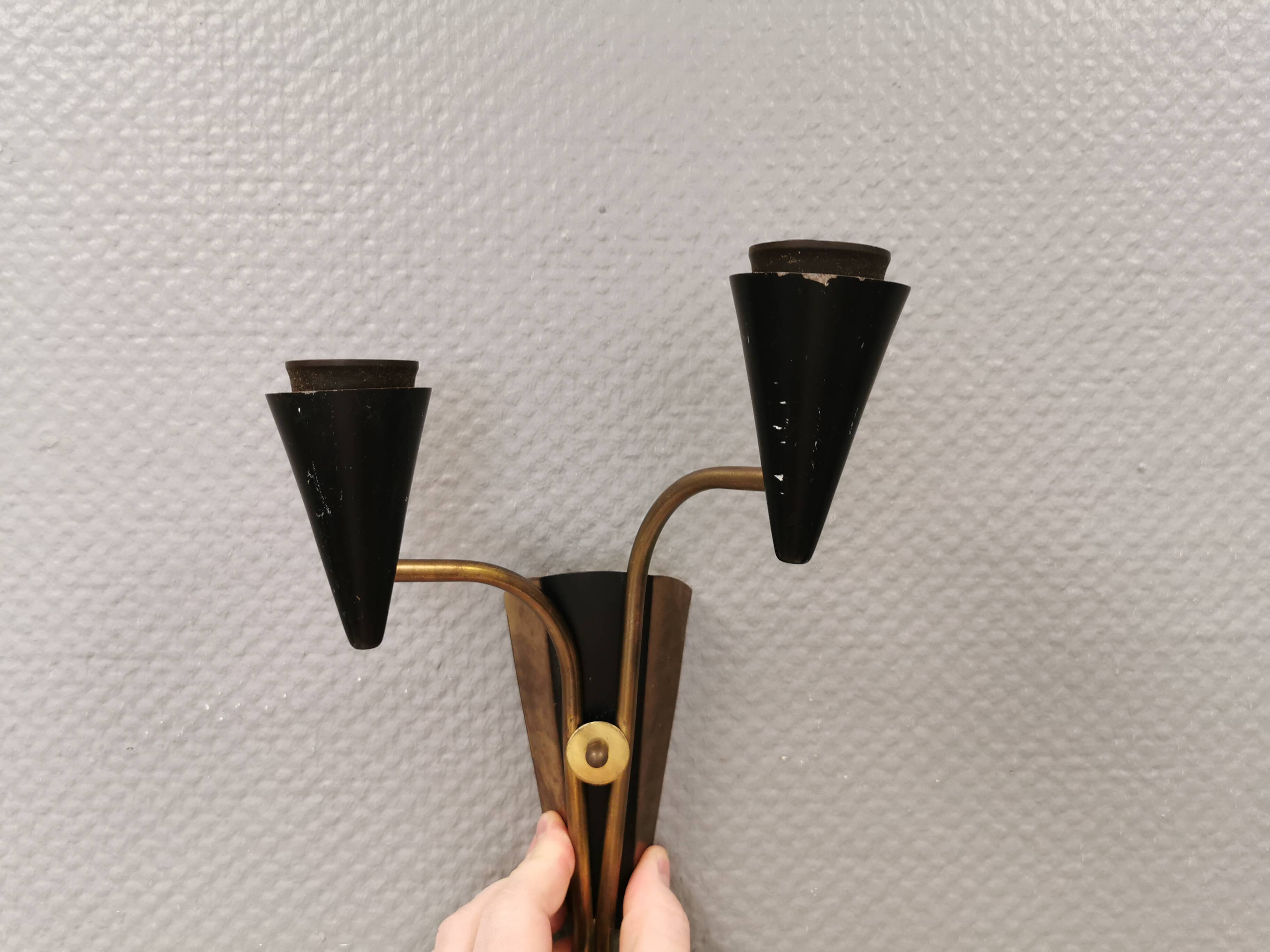 A set of wall lamps in black lacquered metal with brass details