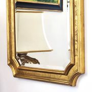 Florentine arched mirror in gilded wood with gold leaf.