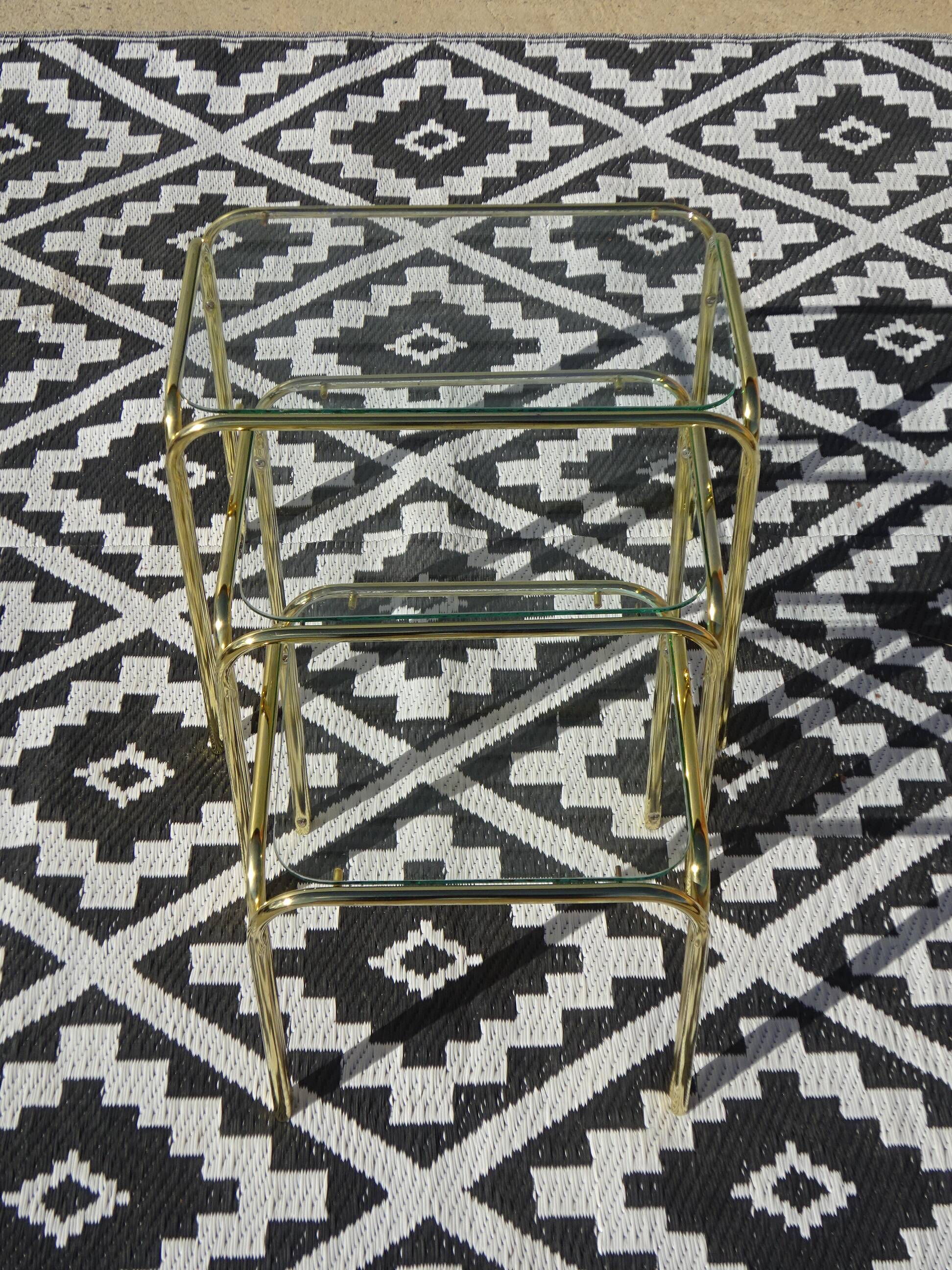 Nested tubular tables in gold metal.