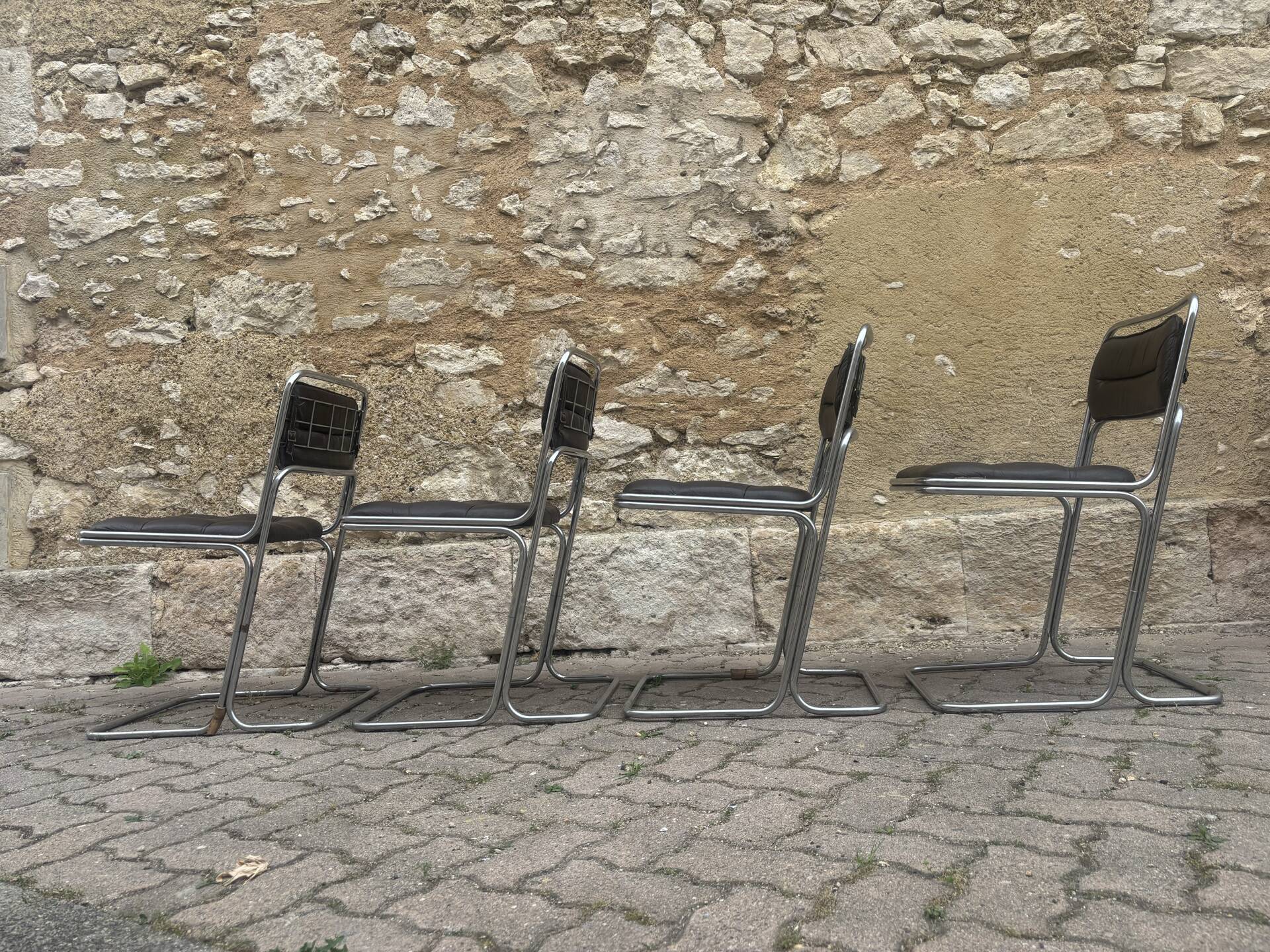 Four vintage chairs from the 1960s and 1970s, chrome with faux leather.