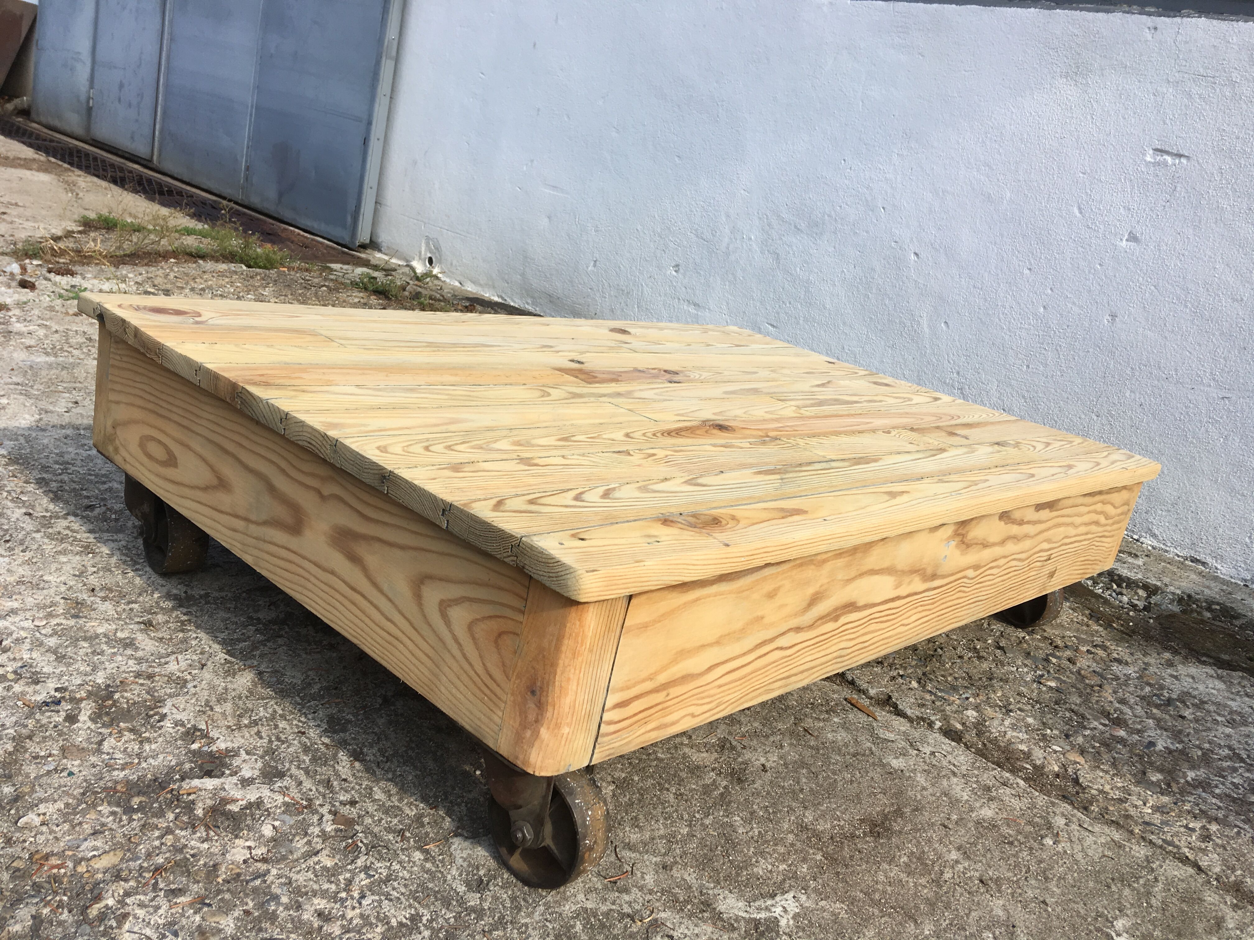 Old wooden school platform bass table on metal wheels