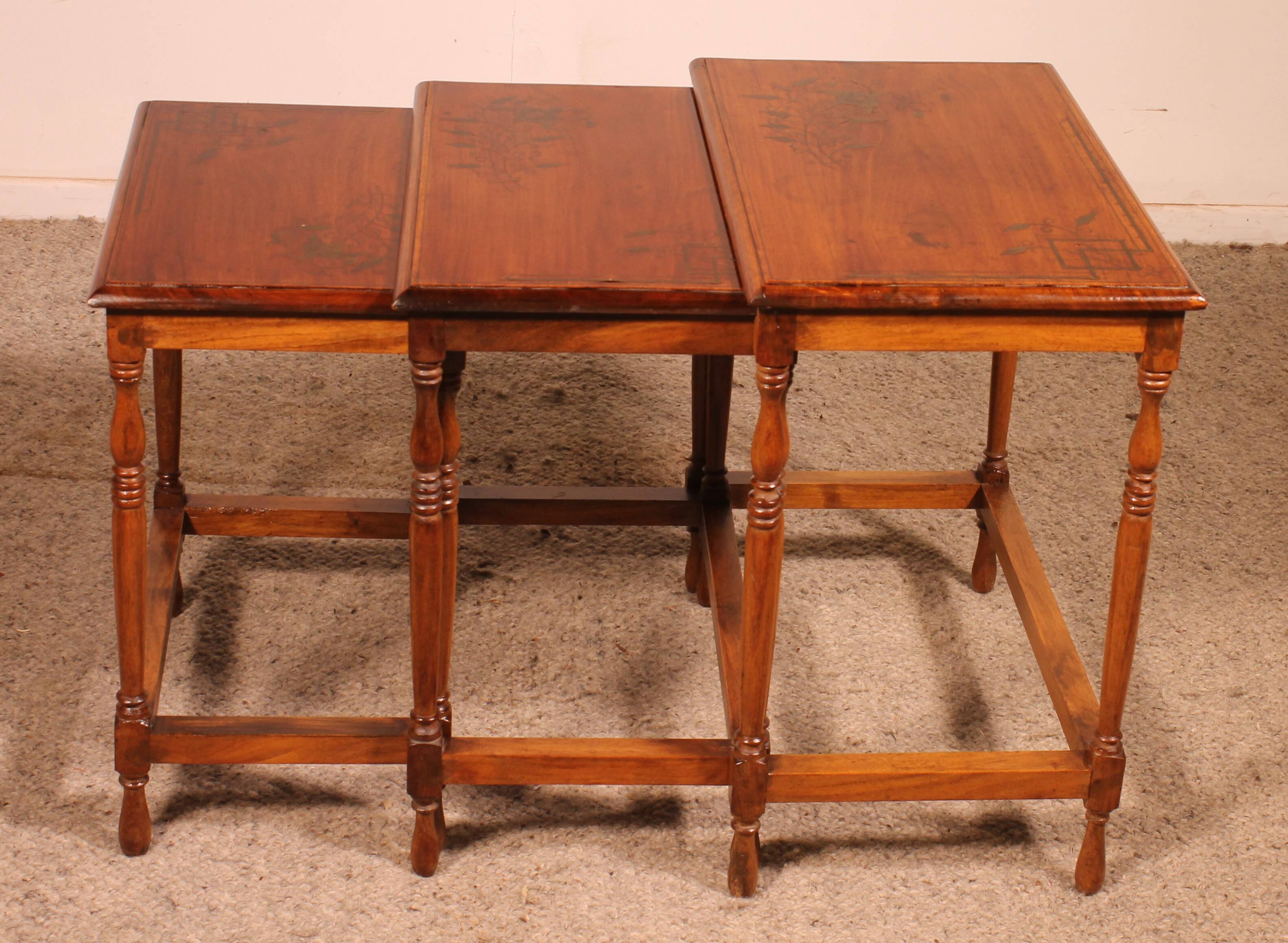 Nested tables in satin wood with brass inlays.