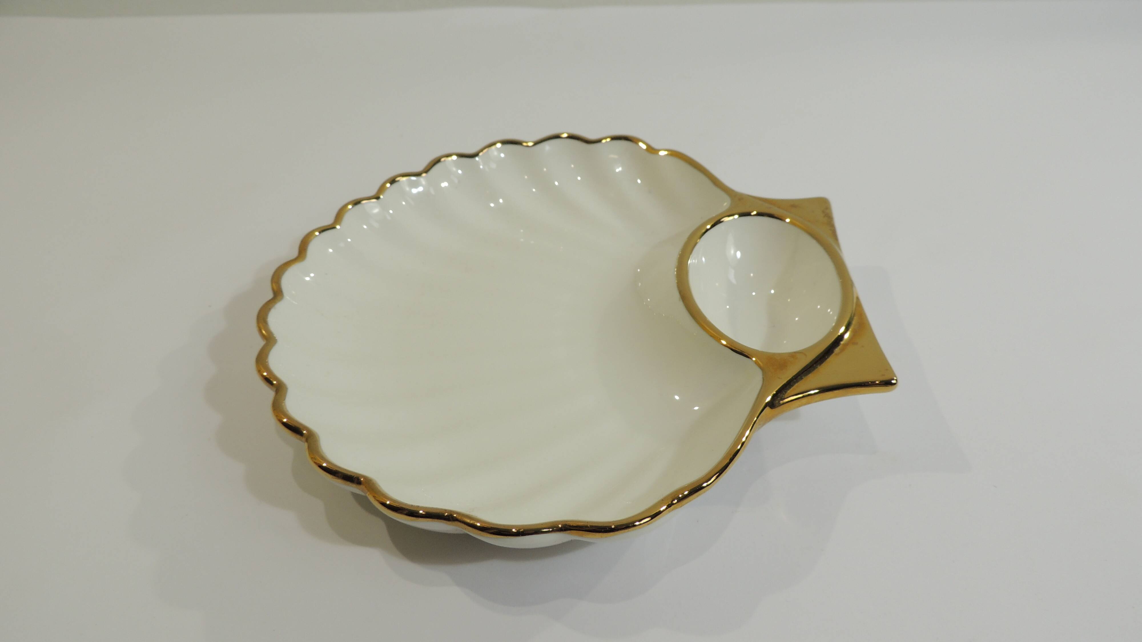 Shell-shaped porcelain pocket bowl from Queen’s Porcelain, with a gold rim.