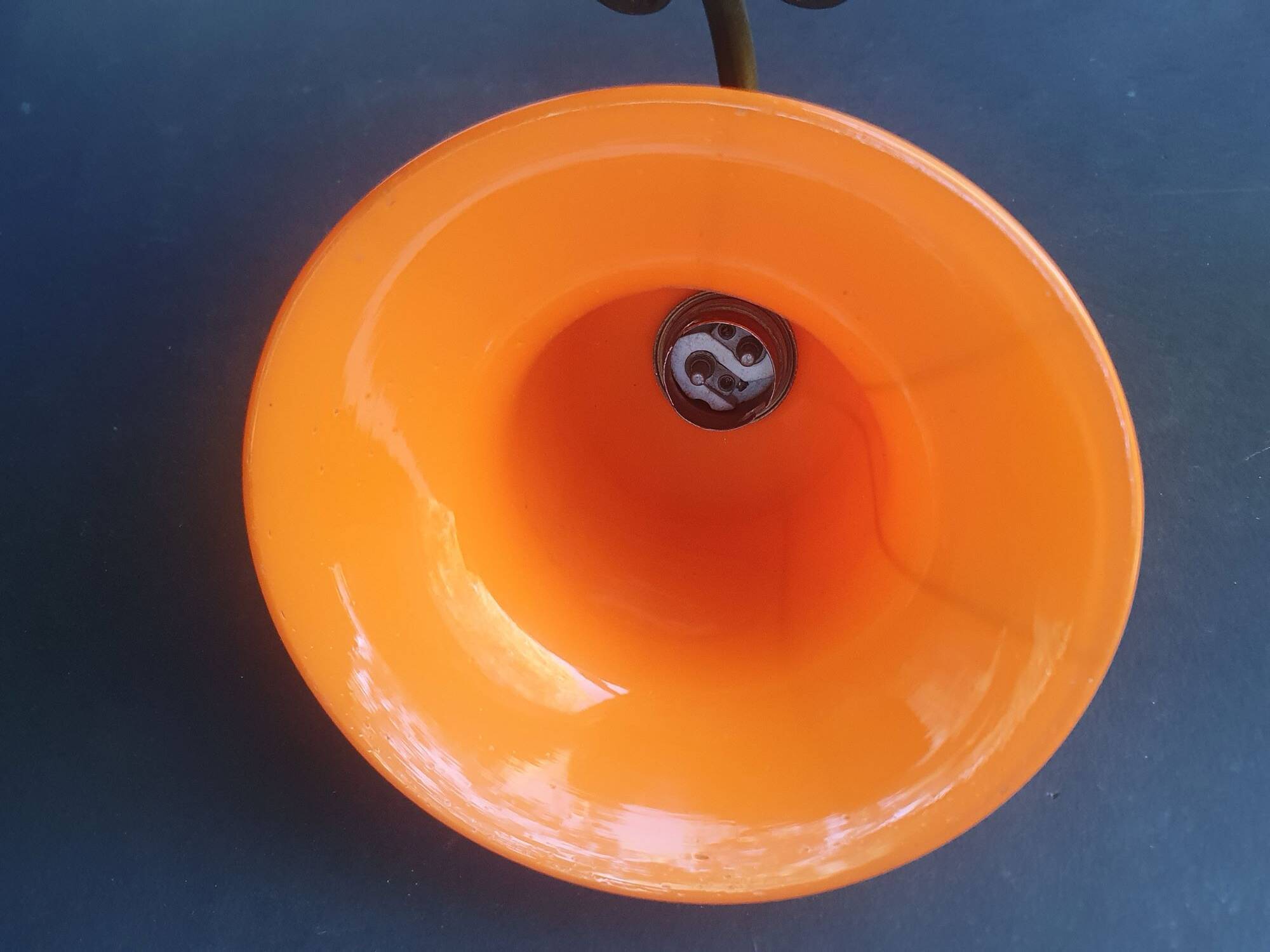 Art Deco wall light in brass with an orange globe.
