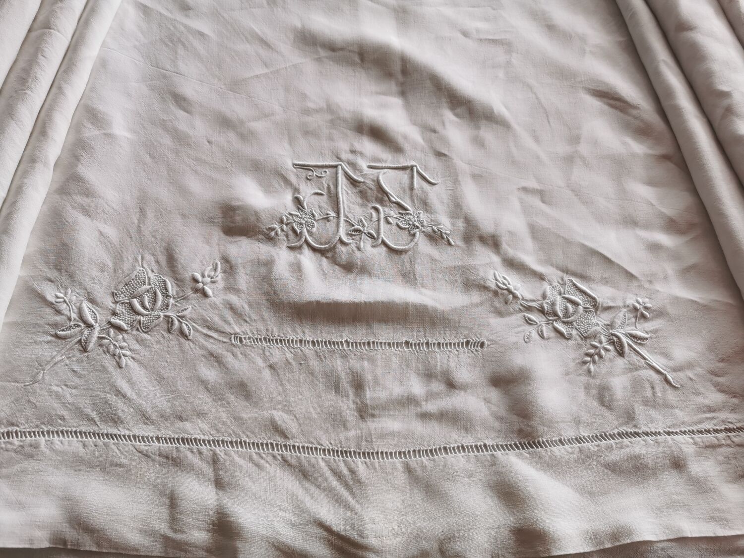 Antique embroidered linen sheet with a monogram.