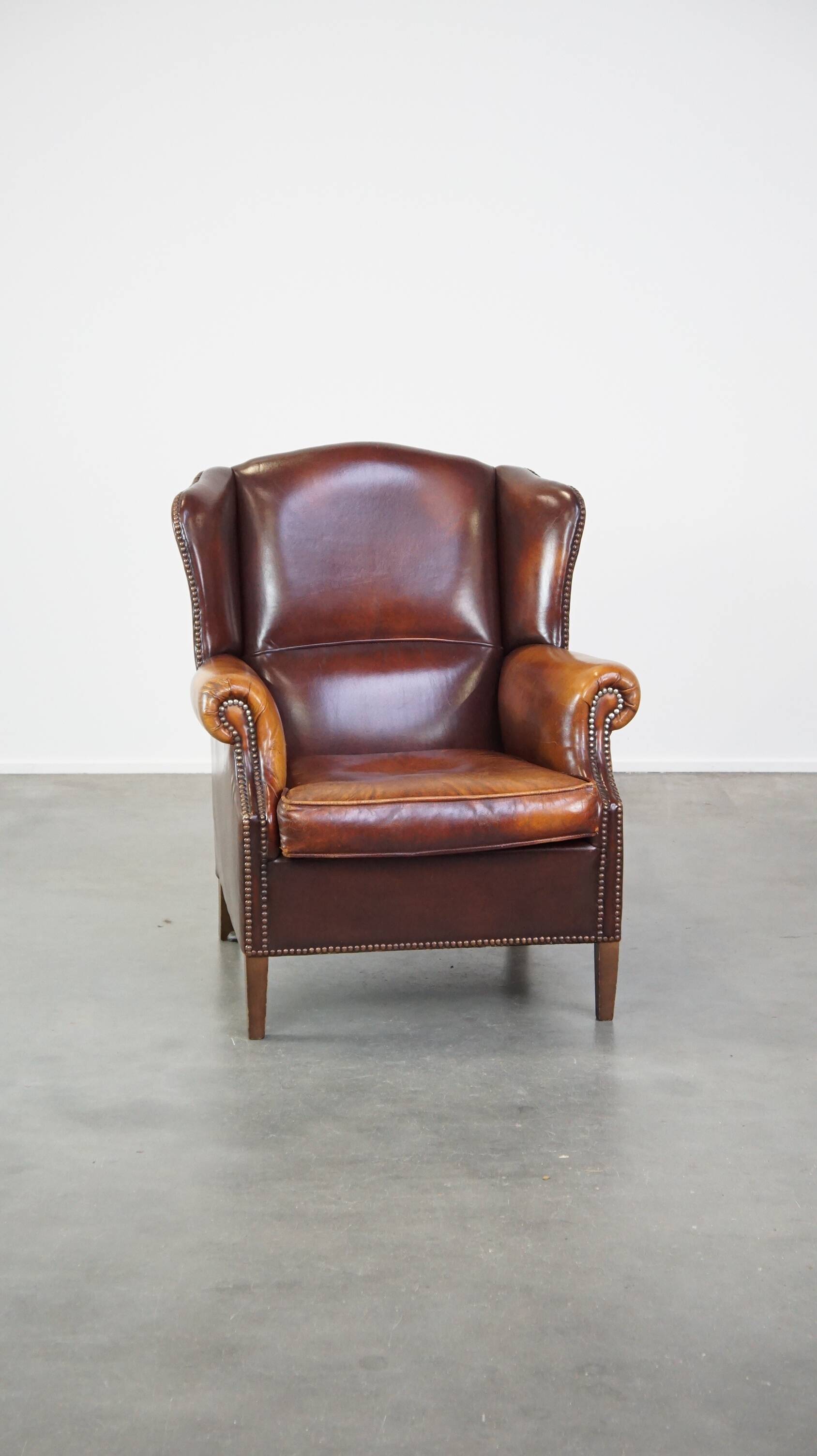 Comfortable, elegant, stately wing chair made of sheepskin in a beautiful warm color