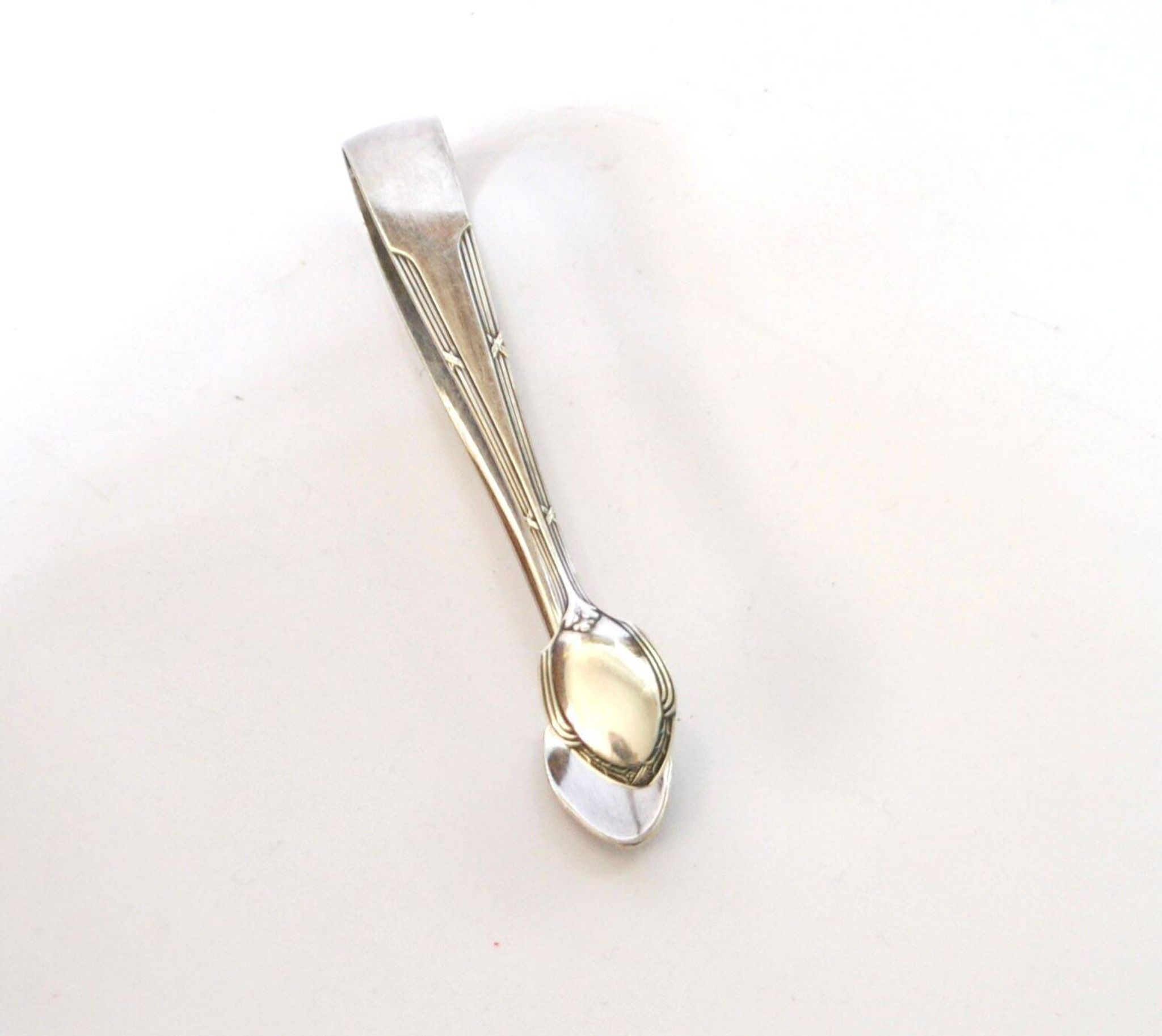 WMF vintage sugar tongs in silver-plated metal with crossed ribbon decoration.