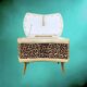 Vintage storage stool with compass legs in white faux leather and leopard velvet.