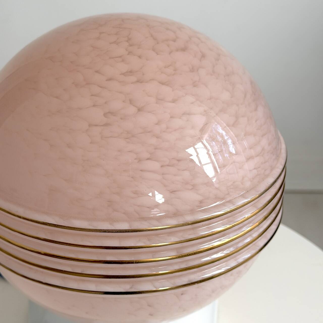 Art Deco lamp with a speckled pink glass globe and a white ceramic base.