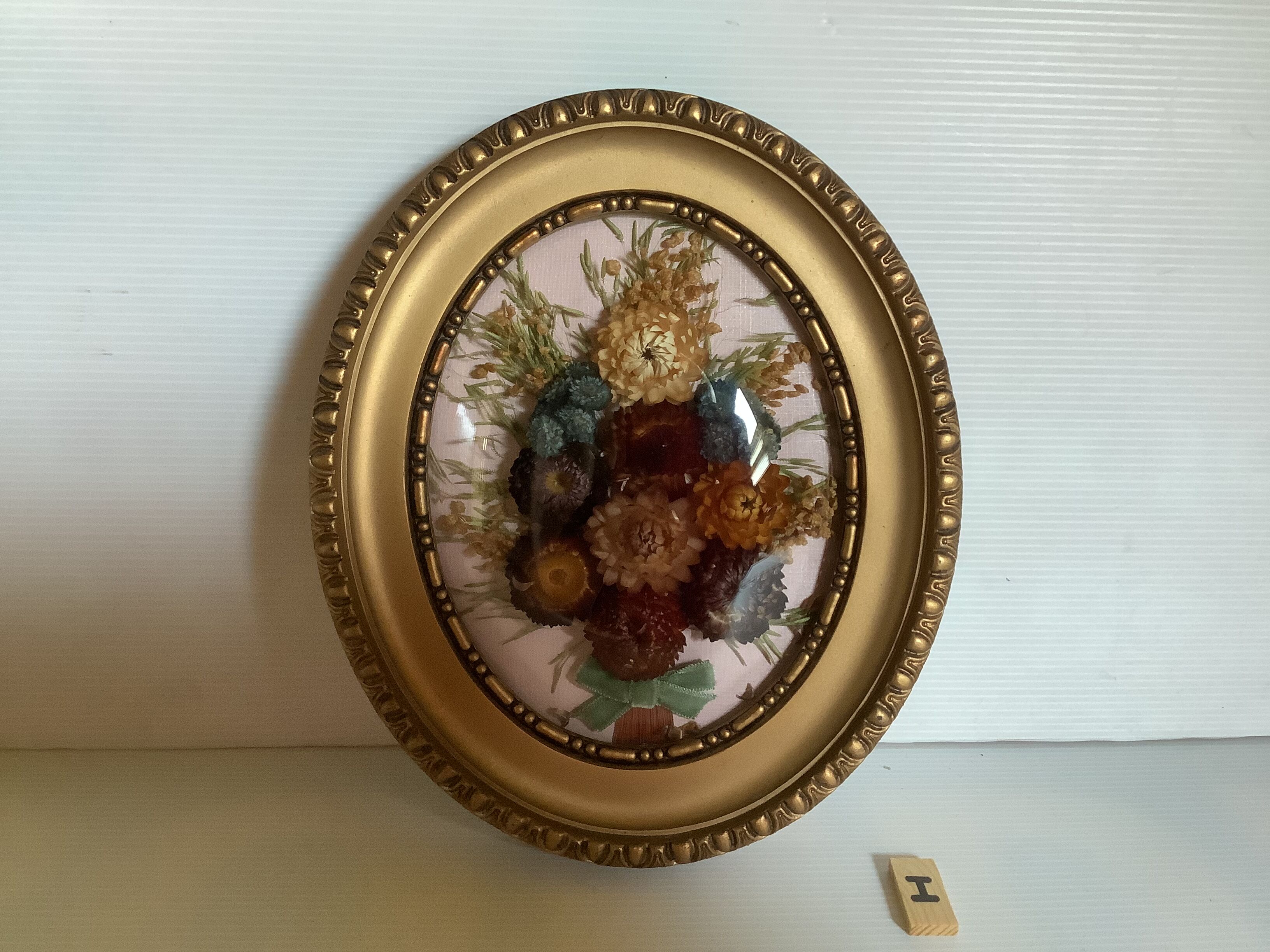 Old frame curved glass dried flowers glossy fabric