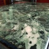 Coffee table in gilded bronze and green Alpine marble