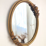 Oval mirror with a gilded frame and carved with bouquets of roses