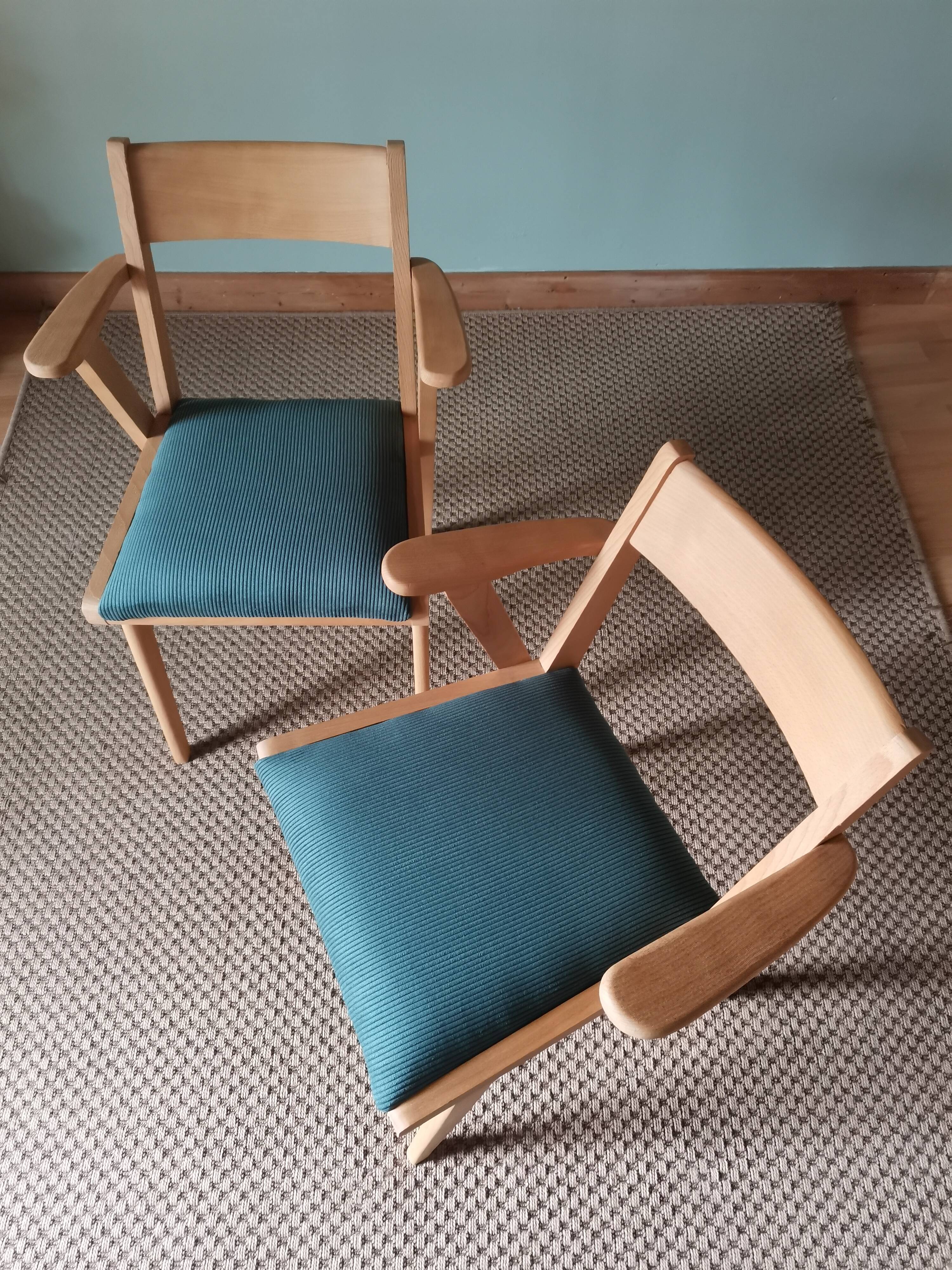 Scandinavian armchairs with green tapered legs.